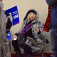 A woman sits alone in the concourse area of the McIntyre-Shaheen 100 Club Celebration on Friday in Manchester, NH.